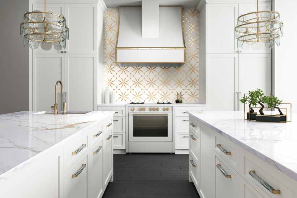 gold tile backsplash behind oven in modern white kitchen with gold accents